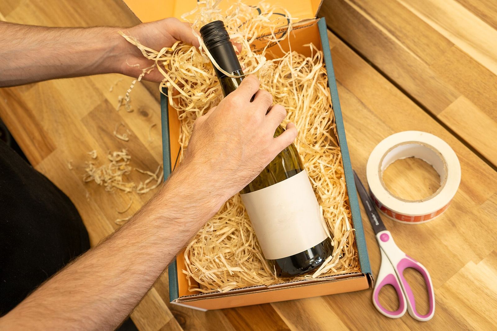 Một chai được chèn vật liệu bảo vệ trong hộp carton