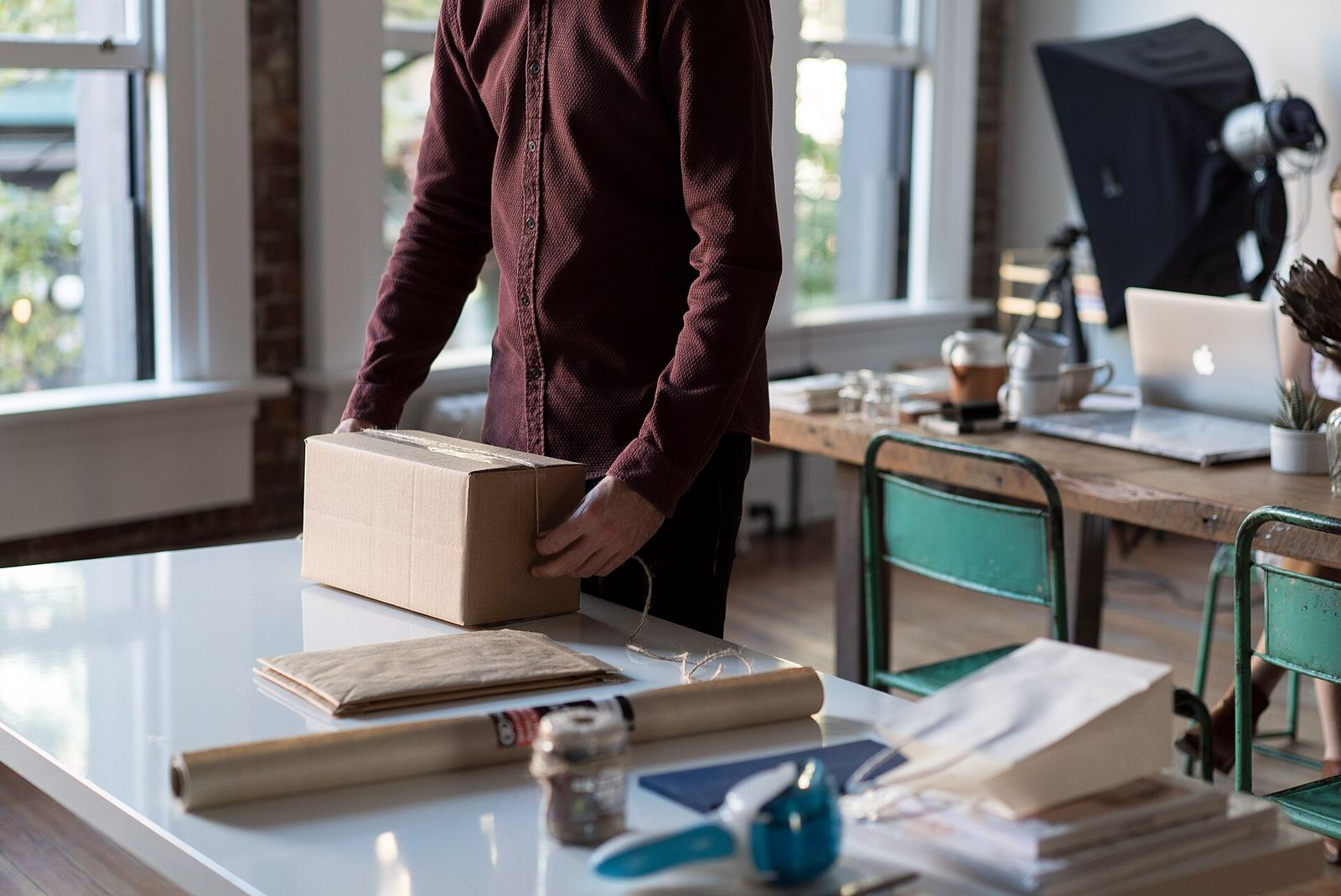 Người bán đóng một thùng carton trên bàn làm việc